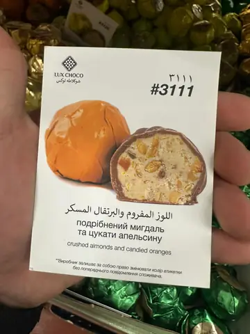 Chocolate-coated candy with crushed almonds and candied orange filling, wrapper and cross-section